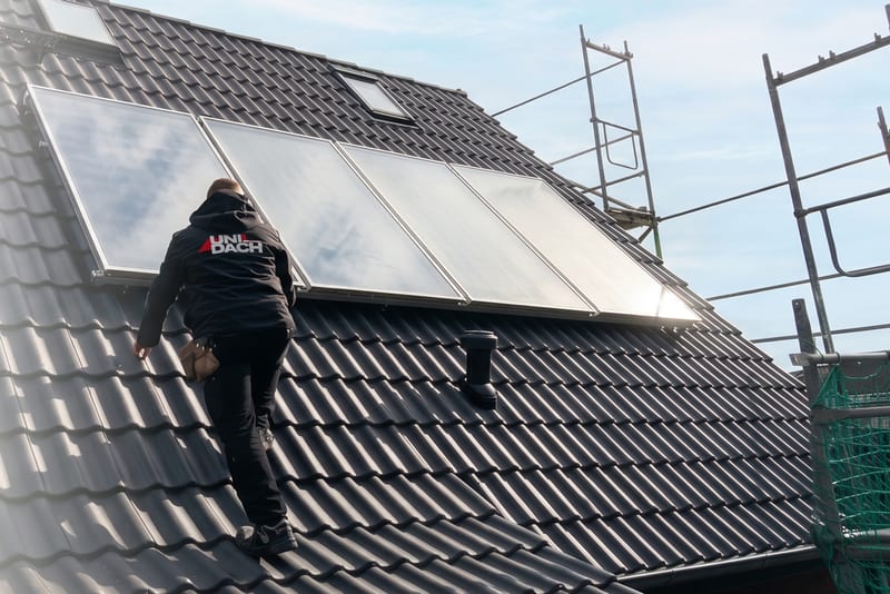 Dachdecker der UNI DACH GmbH bei Montagearbeiten auf einem Steildach mit Solarkollektoren in Hamburg