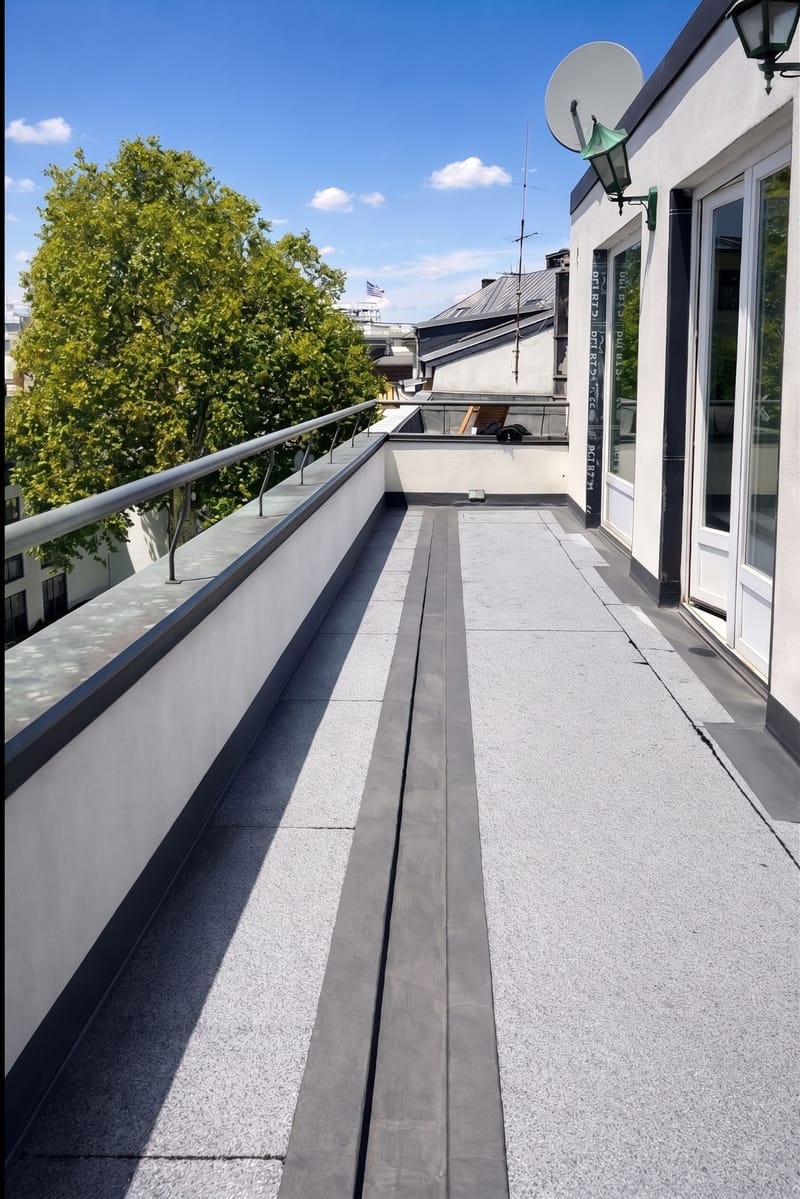 Fertige Dachterrasse mit Granitplatten und Entwässerungsrinne